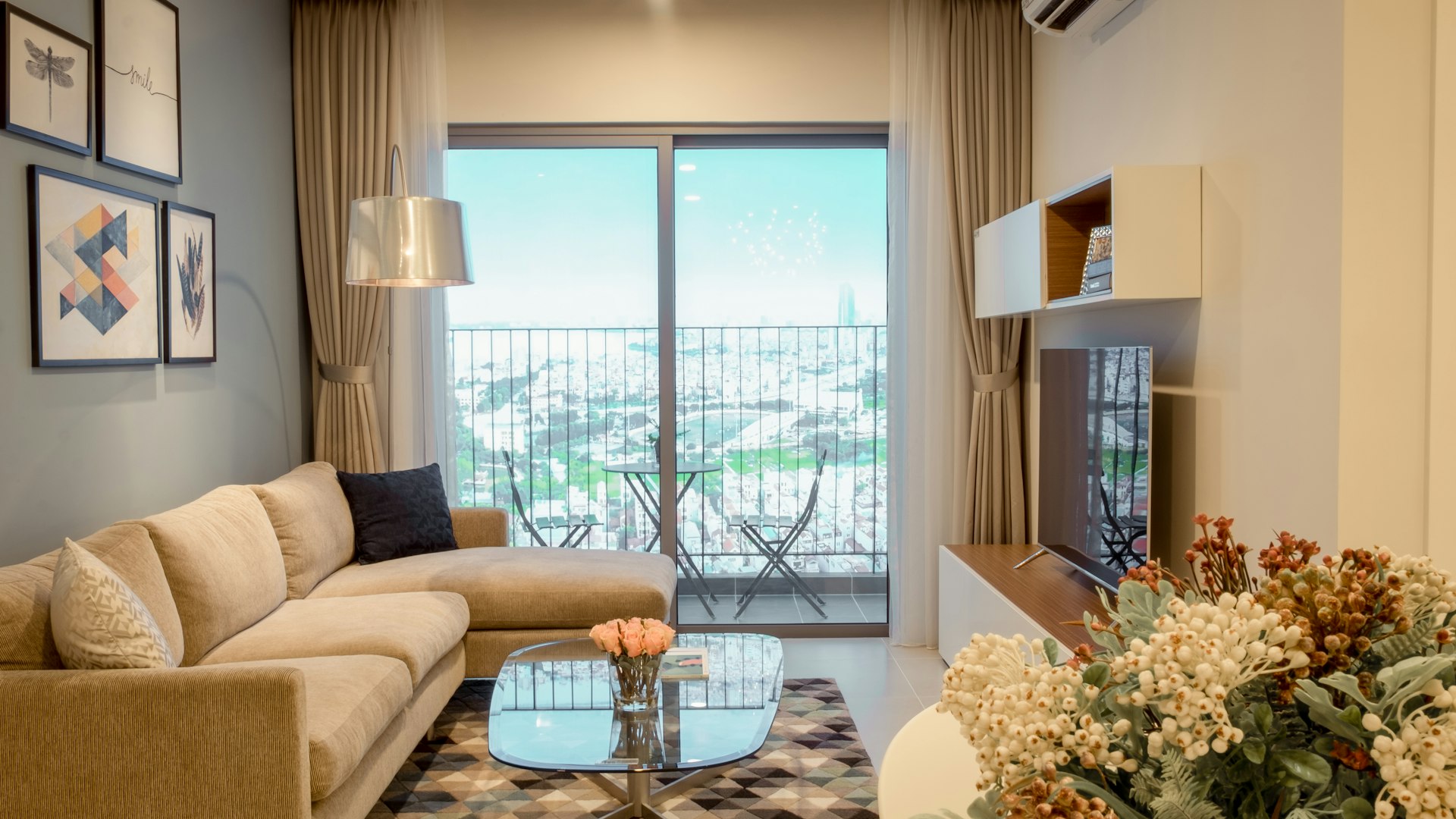 A bright living room with a sofa and a city view through the window