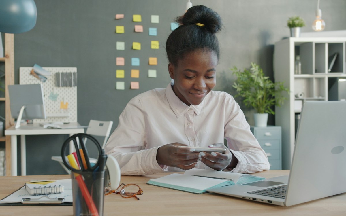A young professional working at an office desk with a laptop and papers